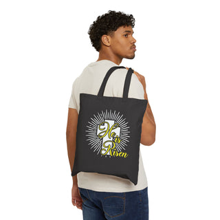 Man carrying a black tote bag with a printed design He is Risen on a white background