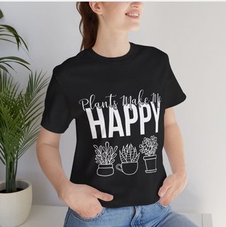 Plants Make Me Happy Unisex T-Shirt showing model posing next to plants wearing shirt.
