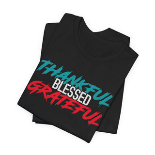 Suggestion


A folded black t-shirt with a graphic print reading 'THANKFUL BLESSED GRATEFUL' in teal, white, and red brushstroke-style lettering, shown on a plain white background.